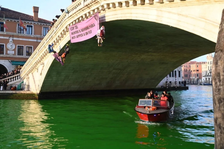 In a protest against COP 28, Extinction Rebellion climate activists color Venice's Grand Canal green